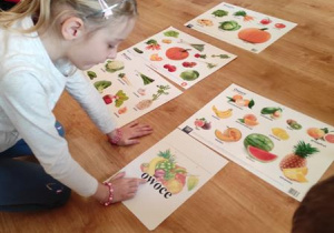 Dzieci rozwiązują zagadki o warzywach i owocach.